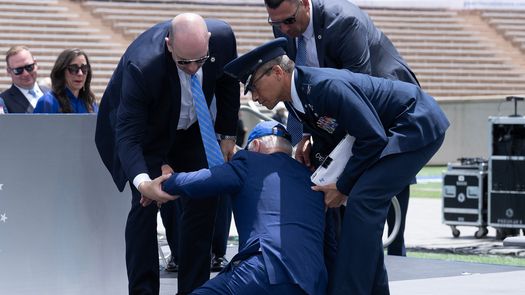 Momento en que agentes de seguridad ayudan a levantarse al presidente Biden.